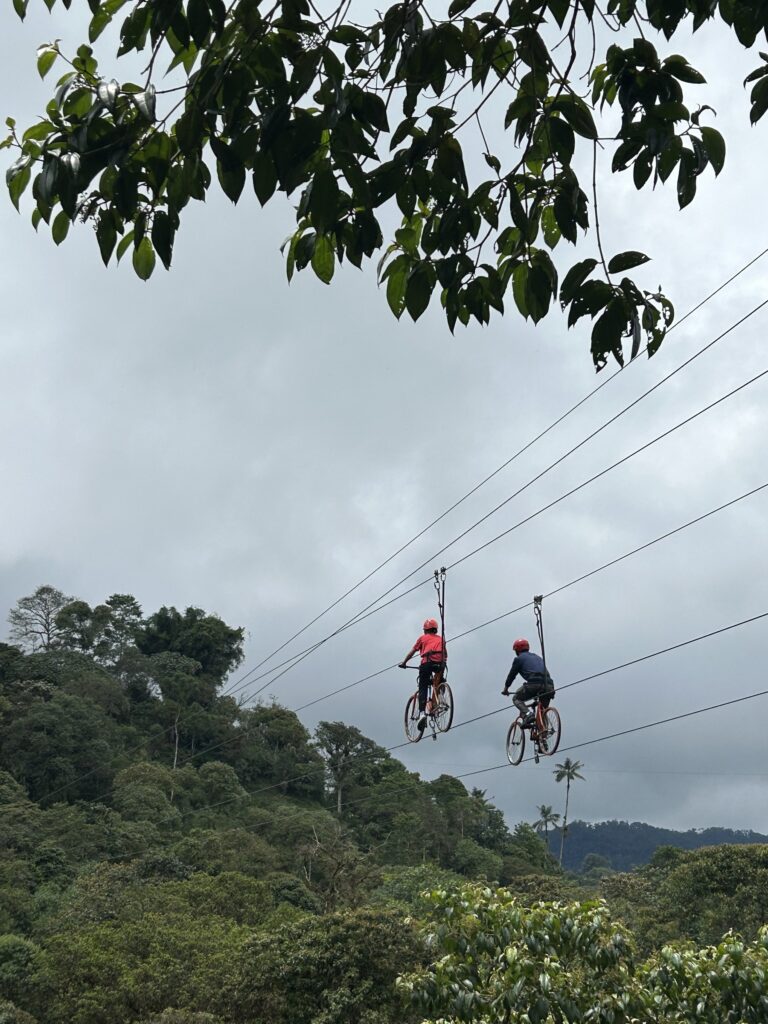 Tarabita cruzando el cable sobre las montañas verdes del bosque nublado de Mindo