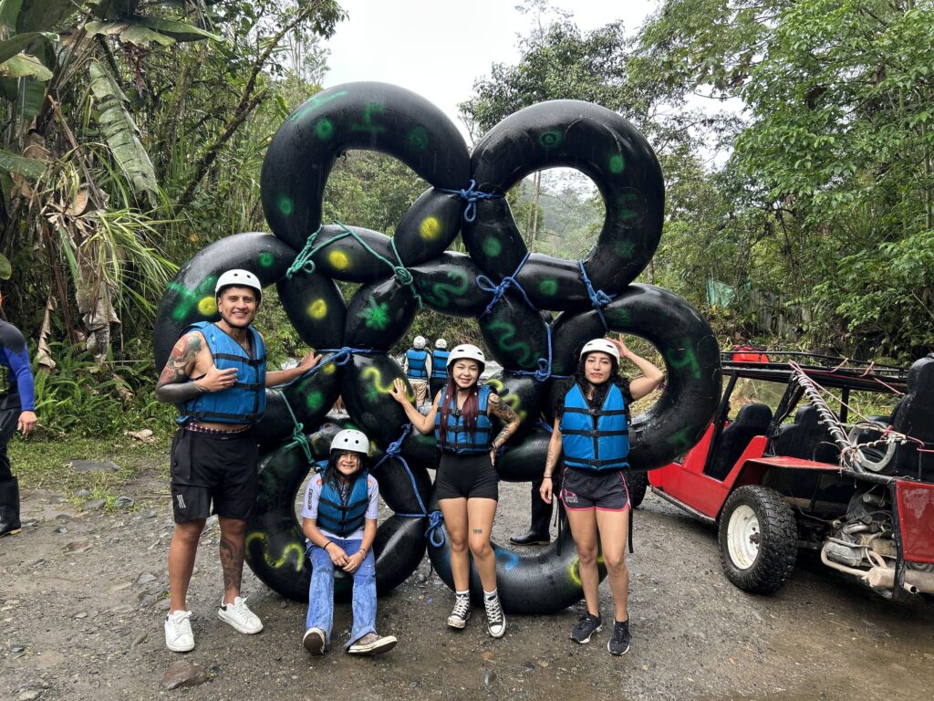 Grupo con casco y chaleco salvavidas listo para el tubing en el río de Mindo
