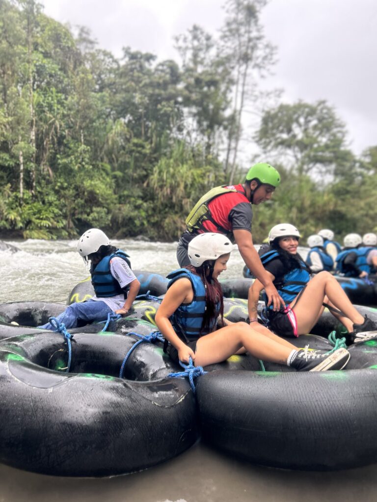 Guía acomodando a los visitantes sobre las balsas de neumáticos en el río