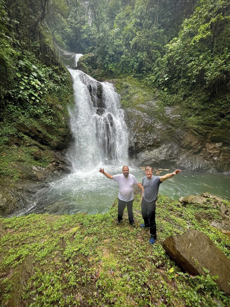 Dos visitantes al pie de la cascada