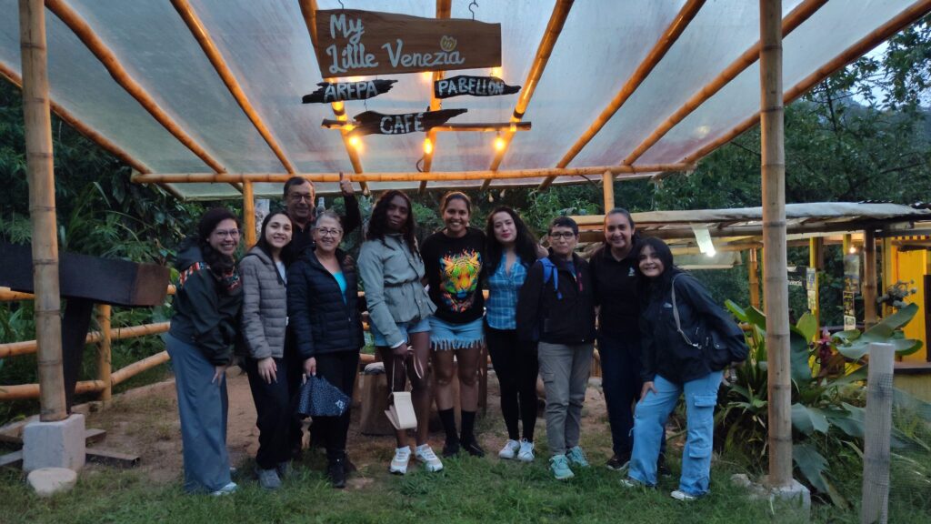 Grupo de visitantes posando bajo una pérgola de caña en un café de Mindo