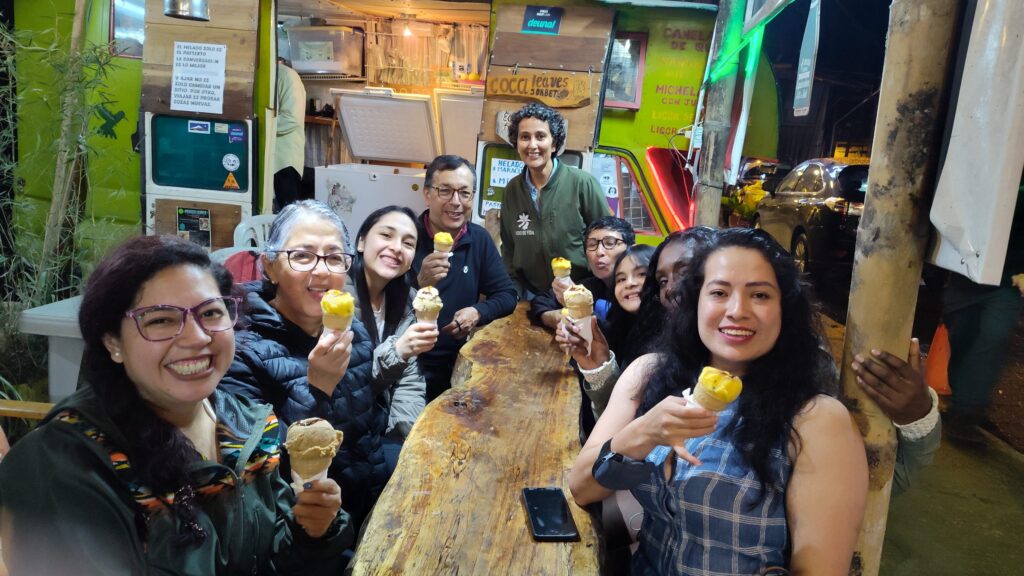 Grupo de visitantes sonriendo con conos de helado en un local de Mindo